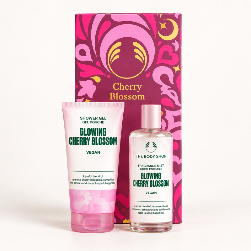 The Body Shop Cherry Blossom Shower Gel and Fragrance Mist set, featuring a pink tube of shower gel and a clear bottle of fragrance mist in front of a decorative pink and magenta gift box.