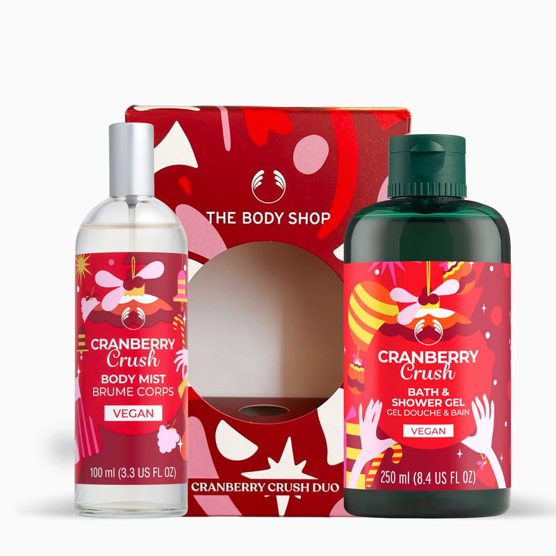 The Body Shop Cranberry Crush Duo gift set featuring a 100ml body mist bottle and a 250ml bath & shower gel bottle, both with red labels and silver/green caps, displayed in front of their red patterned gift box.