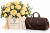 A luxury gift set featuring a large bouquet of pale yellow roses in a cream-colored round box with the 'FLOWRISTA' logo, paired with a dark brown monogram duffel bag with a matching ribbon bow.