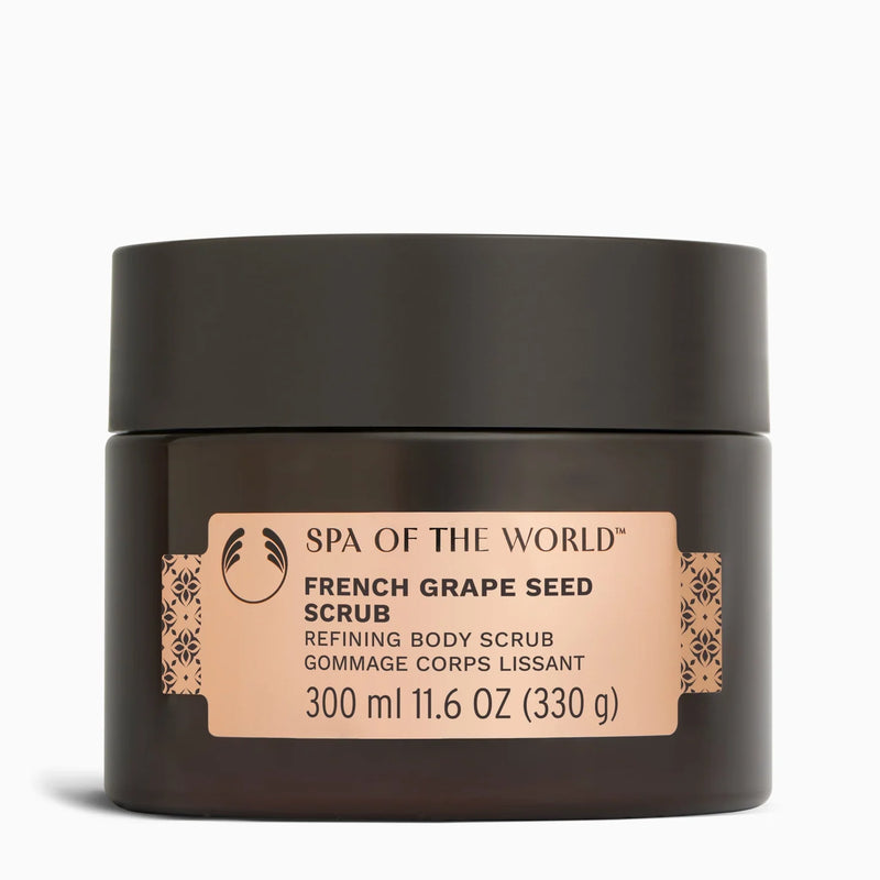 A dark brown jar of Spa of the World French Grape Seed Scrub with a beige label, set against a plain white background.
