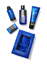 Collection of blue bath and body products including a bottle, tube, and soap on a white background.