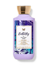 Purple body wash bottle with gold cap and butterfly design on label against white background