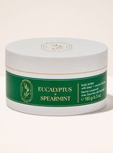 A white plastic jar of Body & Soul Eucalyptus + Spearmint body butter with a green label, set against a solid off-white background.