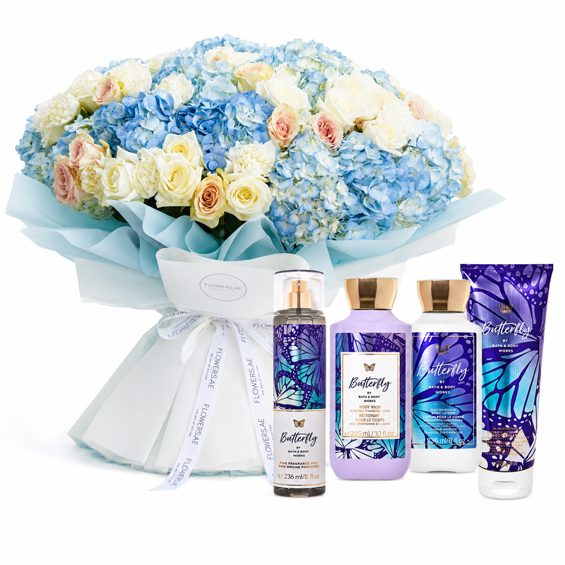 A floral gift set featuring a large bouquet of blue, white, and peach flowers wrapped in light blue paper, alongside four Bath & Body Works Butterfly scented products including a body spray, lotion, hand cream, and a body wash tube.