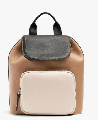 A color-blocked leather backpack in tan, dark gray, and cream, featuring a top handle and a front zippered pocket, shown against a plain white background.