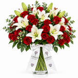 Red roses and white lilies in clear glass vase with Flowrista ribbons