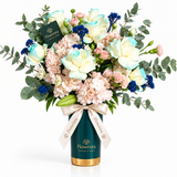 Flowrista pastel roses, blush flowers and blue accents with eucalyptus in a teal and gold vase
