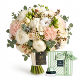Patchi 500g chocolate box with green ribbon beside a white and blush pink Flowrista bouquet