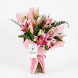 Pink lily bouquet with buds and eucalyptus in pink wrapping with ribbon and a Flowrista gift tag