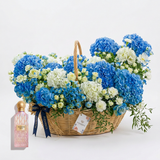 Pink Diamond Sakura perfume beside a blue and white floral basket with navy ribbon and Flowrista tag