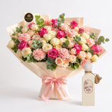 Riviera Sunset perfume beside a Flowrista pink and cream rose carnation bouquet