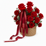 Flowrista red roses woven basket with red satin ribbon on white background