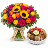 Caramelized sesame tray beside a Flowrista sunflower and colorful rose arrangement in glass vase