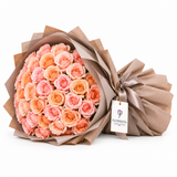 Peach and blush roses in taupe wrapping with a satin bow and Flowrista gift tag
