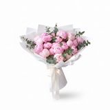 Large pink peony bouquet with eucalyptus in white paper wrapping with cream satin ribbon bow