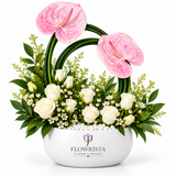 Artificial pink anthuriums and white roses with greenery in a rounded white Flowrista bowl