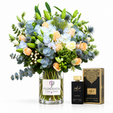 Amir Al Oud Black Intense perfume beside blue hydrangeas and peach roses in a Flowrista glass vase