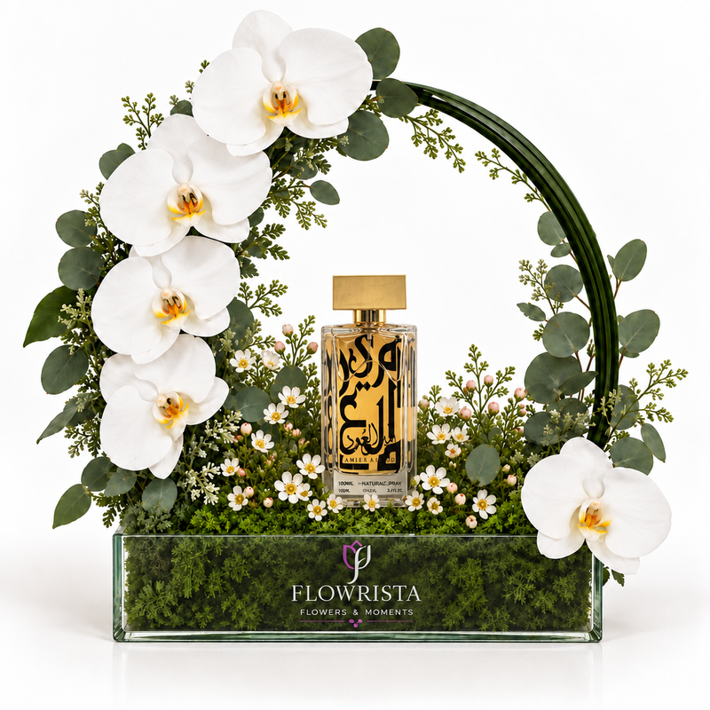 Amir Al Oud Gold 100ml perfume with artificial white orchids and a green arch in a Flowrista box