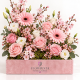 Pink roses and gerberas with white lisianthus and flowering branches in a rectangular pink Flowrista box
