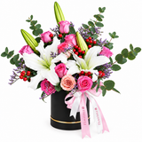Flowrista white lilies and pink and peach roses with red berries in a black hatbox