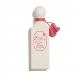 Ocean Whisper cream perfume bottle with rounded white cap and pink neck ornament