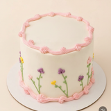 One-kilo Sugar Sweet ivory birthday cake with pink piping and pastel flower decorations