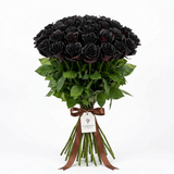 Black rose bouquet with green leaves, exposed stems, brown ribbon and Flowrista gift tag