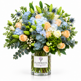 Blue hydrangeas and cream roses in a glass Flowrista vase