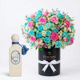 Chasing Waves perfume beside pink and blue roses and white flowers in a tall Flowrista box