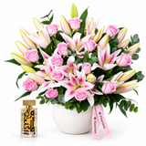 Amir Al Oud Gold perfume beside Flowrista pink roses and pink-and-white lilies in a white pot