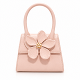 Blush pink AZRA top handle bag with flower appliqué and pearl-gold center