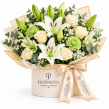 White lilies, cream roses and green carnations in a cream Flowrista box with ribbon