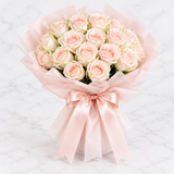 Pale pink and white rose bouquet with soft pink wrapping and satin bow