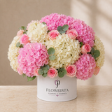 Pink and ivory hydrangeas with pink roses and eucalyptus in a white Flowrista hatbox