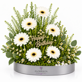 Fresh white gerberas with greenery and a gold Happy Birthday topper in a grey oval Flowrista tray