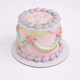 One-kilo Sugar Sweet pale-pink vintage cake with pastel piping, bows and colorful sprinkles