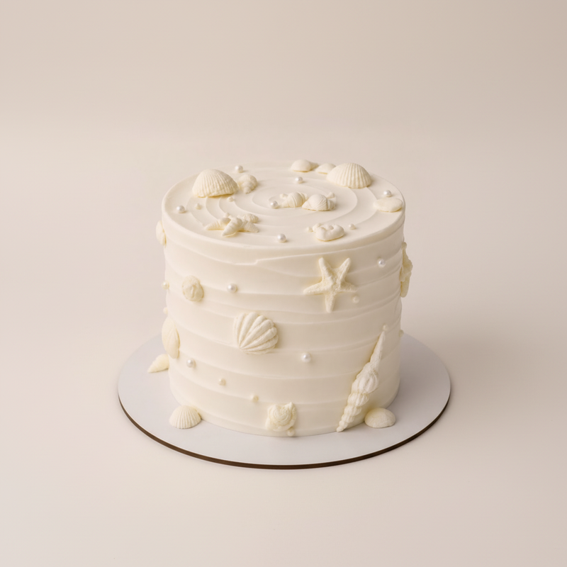 One-kilo Sugar Sweet white celebration cake with seashell, pearl and butterfly decorations